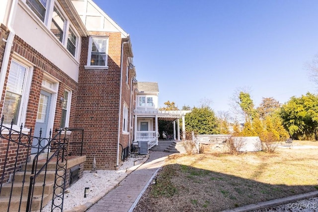 view of yard with central AC and a pergola