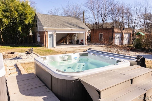 view of pool featuring an outdoor hot tub, an outdoor fire pit, and an outdoor structure