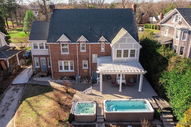 back of property featuring a pergola, an outdoor hot tub, and cooling unit