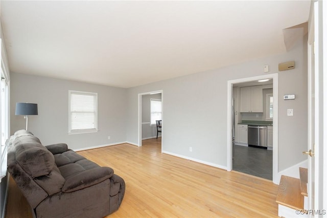 living area with light wood-style flooring and baseboards