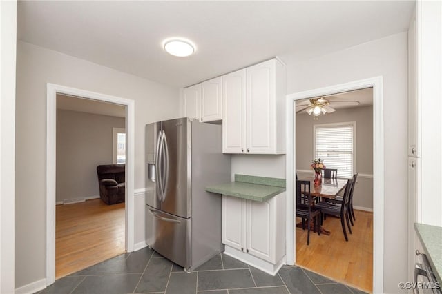 kitchen featuring white cabinets, dark tile patterned floors, stainless steel refrigerator with ice dispenser, and light countertops