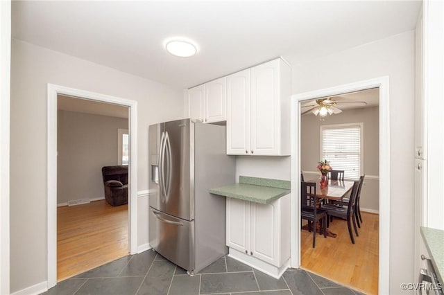 kitchen with dark wood-style floors, white cabinets, and stainless steel fridge