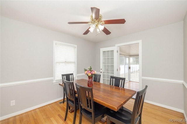 dining space featuring light wood-style floors, ceiling fan, and baseboards