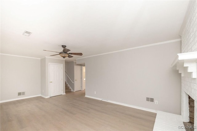 unfurnished living room featuring visible vents, stairway, ornamental molding, wood finished floors, and a fireplace