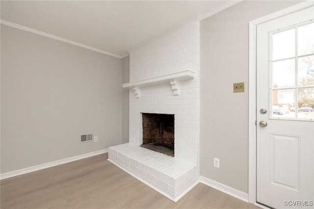 unfurnished living room with visible vents, ornamental molding, a brick fireplace, light wood-type flooring, and baseboards