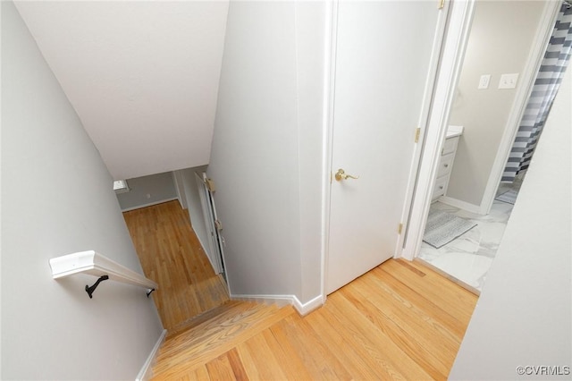 stairway featuring baseboards and wood finished floors