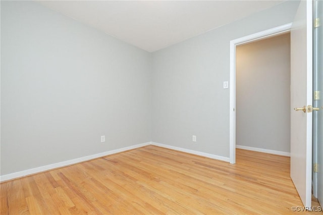 empty room with light wood finished floors and baseboards