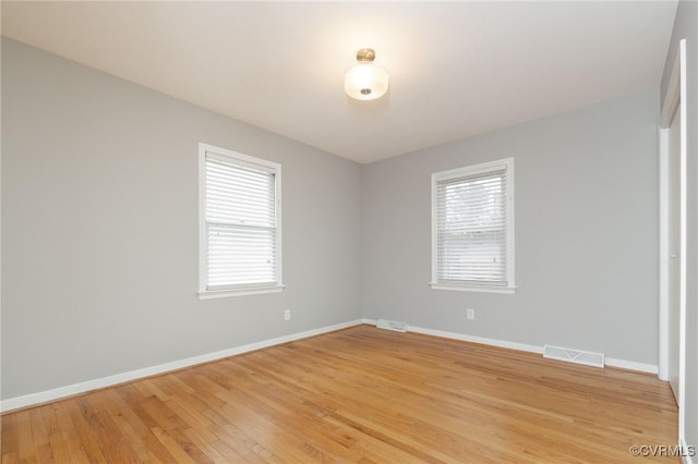 spare room with plenty of natural light, visible vents, and baseboards