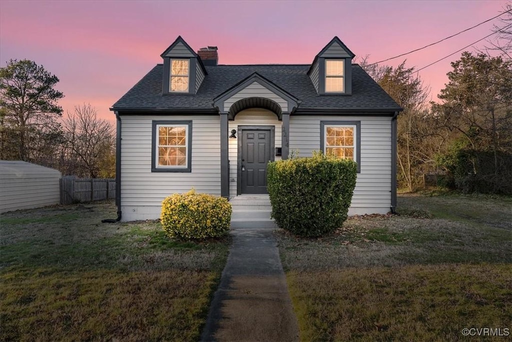 new england style home featuring a yard