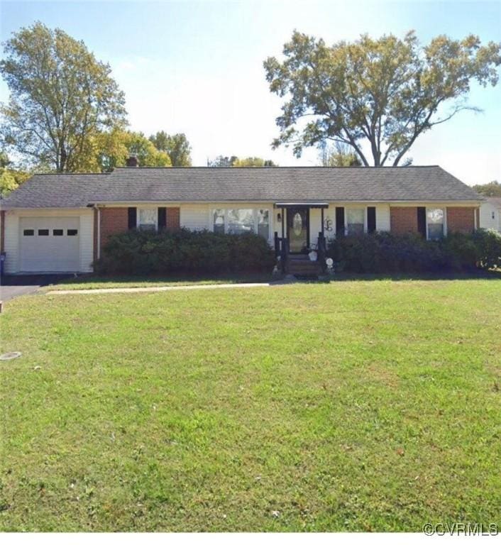 ranch-style home with a garage, brick siding, driveway, and a front lawn