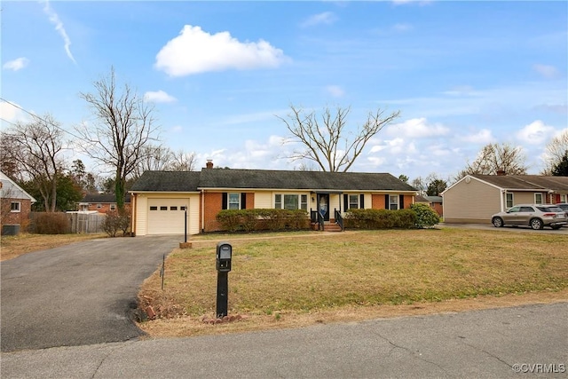 single story home with aphalt driveway, a garage, brick siding, fence, and a front yard