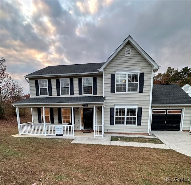 view of front of property featuring a garage, a front yard, and covered porch