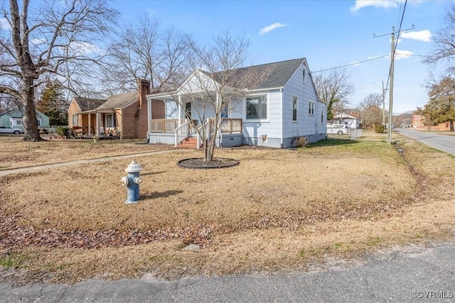 view of front facade featuring covered porch, crawl space, and a chimney