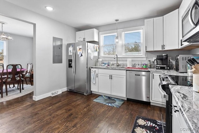 kitchen with stainless steel appliances, hanging light fixtures, visible vents, and white cabinets