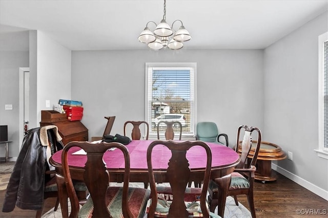 dining space featuring dark wood-style floors, baseboards, and an inviting chandelier