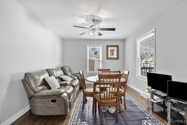 dining space with ceiling fan, dark wood-style flooring, and baseboards