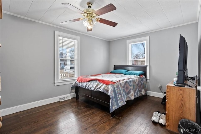 bedroom with ceiling fan, visible vents, baseboards, ornamental molding, and dark wood finished floors