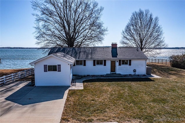 ranch-style home featuring a water view and a front lawn