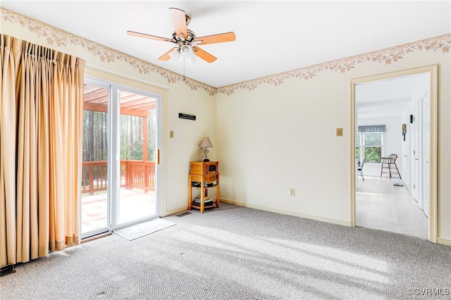 carpeted spare room with ceiling fan and baseboards