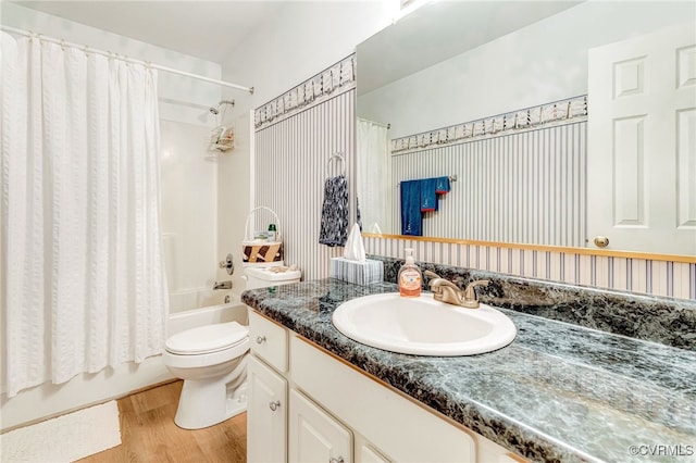 bathroom featuring toilet, vanity, shower / tub combo with curtain, and wood finished floors