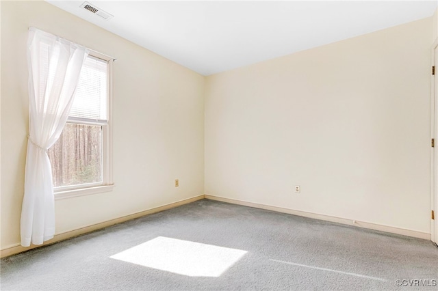 empty room featuring carpet floors, baseboards, and visible vents