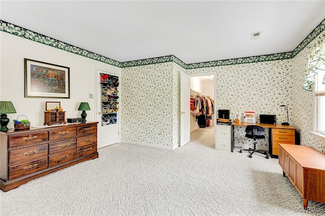 office featuring light colored carpet, visible vents, and wallpapered walls