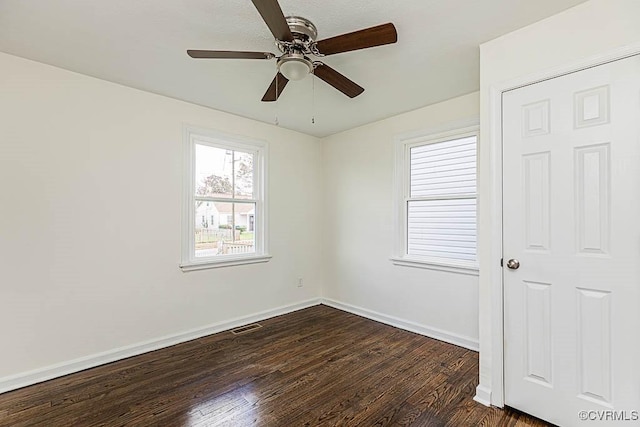 spare room with dark wood-type flooring and ceiling fan