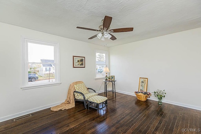 sitting room with ceiling fan, wood-type flooring, and a textured ceiling