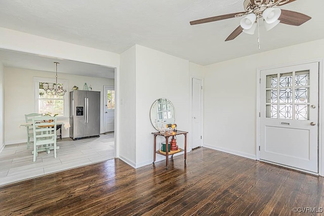 foyer featuring hardwood / wood-style flooring and ceiling fan with notable chandelier