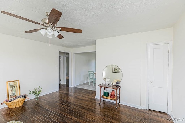 unfurnished room featuring ceiling fan, a textured ceiling, and dark hardwood / wood-style flooring