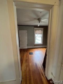 hallway with wood finished floors and baseboards