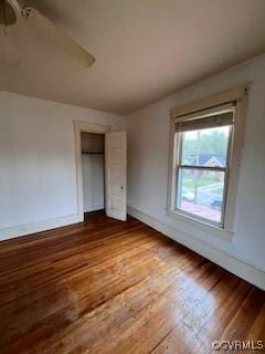 unfurnished bedroom with a ceiling fan, a closet, baseboards, and wood finished floors