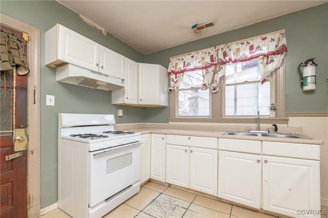 kitchen featuring white cabinetry, light tile patterned flooring, sink, and white range with gas stovetop