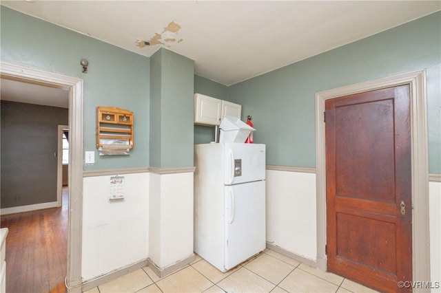 kitchen featuring white cabinetry, white fridge, and light tile patterned floors