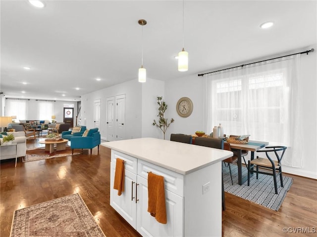 kitchen featuring white cabinetry, a healthy amount of sunlight, decorative light fixtures, and dark wood-type flooring