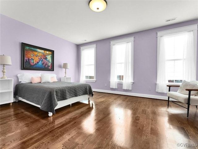 bedroom featuring dark hardwood / wood-style floors and multiple windows