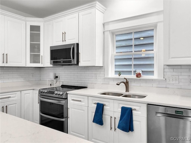 kitchen featuring white cabinetry, stainless steel appliances, sink, and backsplash