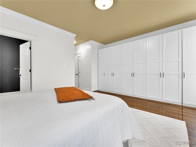 bedroom featuring hardwood / wood-style floors and crown molding