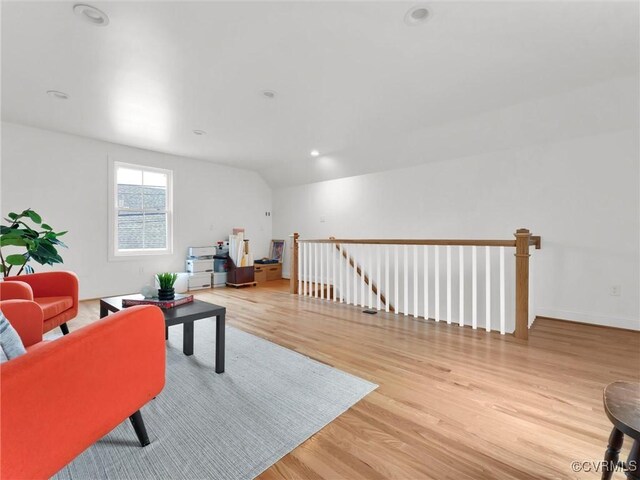 living room featuring vaulted ceiling and light hardwood / wood-style floors