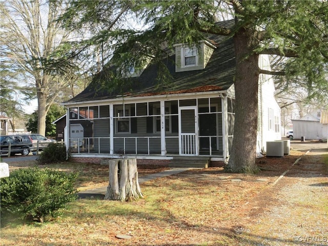 view of front of home with a sunroom and central AC unit