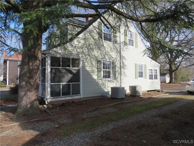 view of side of property with a sunroom and central air condition unit