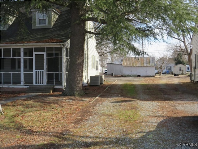 view of side of home featuring a sunroom and central air condition unit