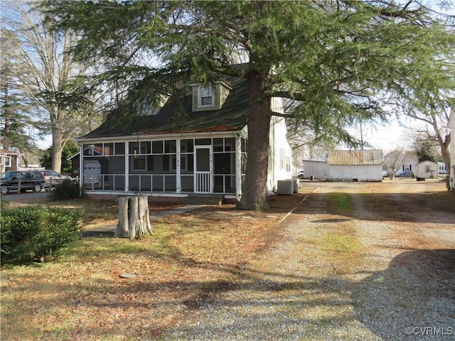 view of side of property with a sunroom and central air condition unit