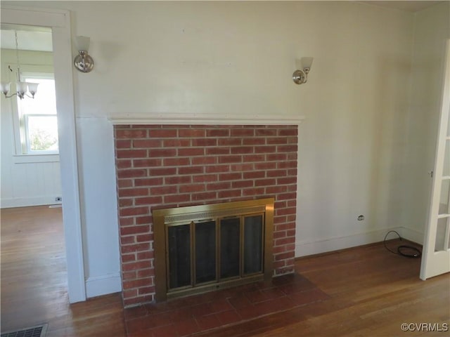 interior details featuring wood-type flooring, a notable chandelier, and a fireplace