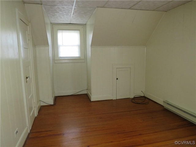 bonus room with a baseboard heating unit, vaulted ceiling, and dark hardwood / wood-style floors