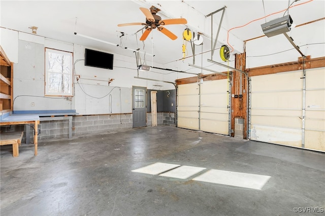 garage with a garage door opener and concrete block wall