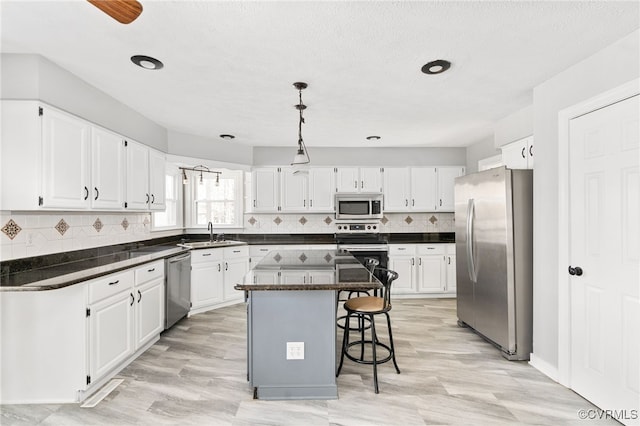 kitchen featuring appliances with stainless steel finishes, a kitchen island, and white cabinetry