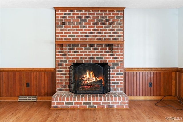 room details featuring wainscoting, visible vents, and wood walls