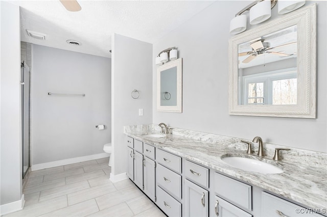 bathroom featuring a ceiling fan, visible vents, and a sink