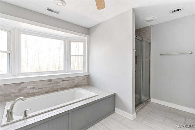 bathroom featuring a garden tub, visible vents, and a textured ceiling